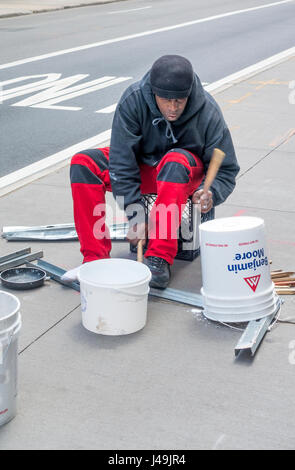 Batteur de bucker africain jouant des rythmes complexes sur des seaux en plastique et objets métalliques Banque D'Images