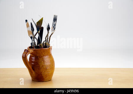 Beaucoup d'artistes couteaux utilisés dans un vieux pot avec un fond blanc copy space Banque D'Images