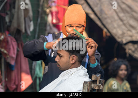 Man getting a haircut dans la rue New Delhi, Inde. Banque D'Images