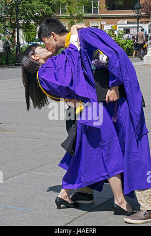 Les diplômés de l'Université de célébrer taiwanais pour leur maîtrise avec un baiser passionné à Washington Square Park à Greenwich Village, New York City Banque D'Images