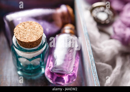 Bouteille avec de l'huile de lavande aromatique et de sel de mer dans une boîte en bois. Close-up. Focus sélectif. Thème parfum et spa Banque D'Images