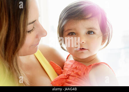 Baby Girl en cours dans les bras de mère Banque D'Images