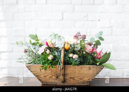 Variété de belles fleurs dans le panier en bois Banque D'Images