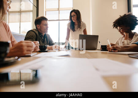 Groupe de travail d'équipe multiraciale séance dans la salle de conférence. Les créatifs ayant nouveau projet discussion en bureau. Banque D'Images