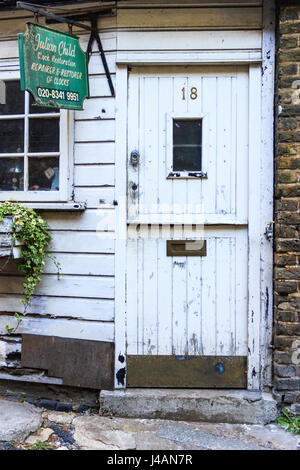 Porte en bois peint en blanc et vert signe des locaux de restauration de l'horloge de l'enfant Julien, Highgate Village, London, UK, depuis déménagé