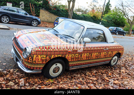 Voiture Nissan Figaro, personnalisées avec des impressions à partir de Lizzie Montgomery, reflétant l'automne les feuilles marron dans lequel il est garé Banque D'Images