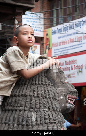 Petit garçon qui est monté sur un Lion Golden Temple à PATAN ou LALITPUR pour regarder le Bouddha jour processions, Katmandou Népal Banque D'Images
