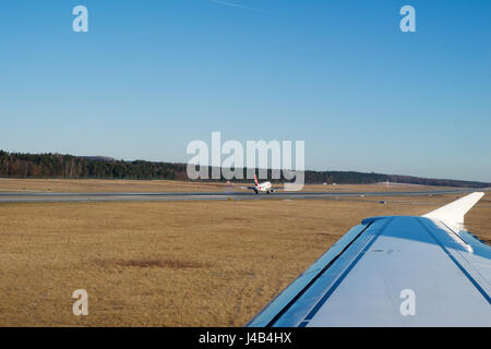 NUREMBERG, ALLEMAGNE - JAN 20th, 2017 : fenêtre d'avions vue sur le tarmac de l'aéroport de Nuremberg, l'Airbus A320 Air Berlin est l'atterrissage dans l'arrière-plan Banque D'Images