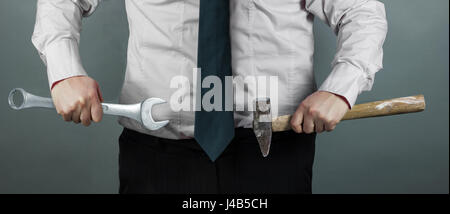 Businessman holding hammer et spinner dans la main Banque D'Images