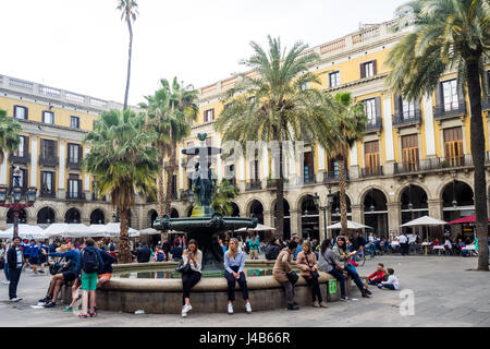 Les touristes assis sur le bord de la fontaine centrale en Placa Reial, Barcelone, Espagne. Banque D'Images