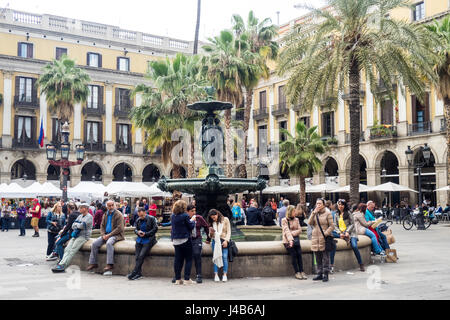 Les touristes assis sur le bord de la fontaine centrale en Placa Reial, Barcelone, Espagne. Banque D'Images