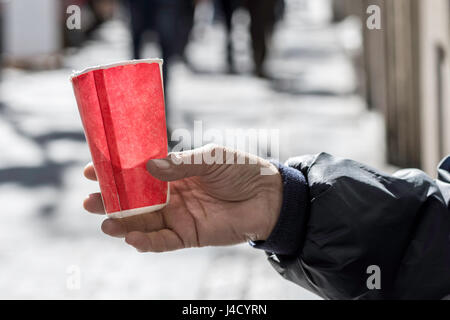 Pauvre homme mendier de l'argent sur la rue Close Up. Mendiant sale Hand Holding Paper Cup Banque D'Images