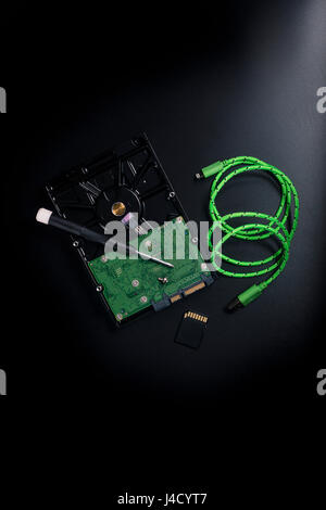 pose à plat du disque dur, du câble, de l'intérieur, d'un tournevis, d'une carte mémoire sd sur l'arrière-plan Banque D'Images