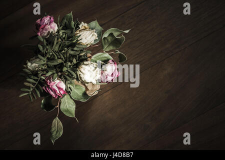 Bouquet de roses rouges et blanches se dresse sur la table basse en bois, gros plan photo clé avec soft focus sélectif. Vue d'en haut Banque D'Images