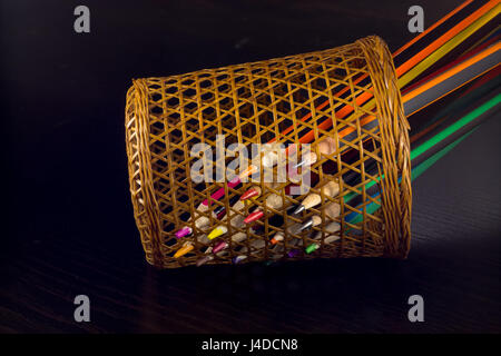 Conseils pointus de crayons de couleur à partir de sections d'affûtage d'un tube d'osier, sur un fond de bois foncé Banque D'Images