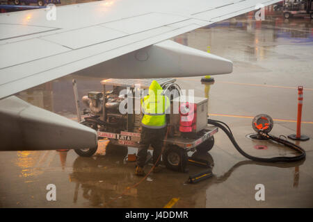 Chicago, Illinois - un travailleur fossiles un avion Southwest Airlines sur un soir de pluie à l'aéroport de Midway. Banque D'Images