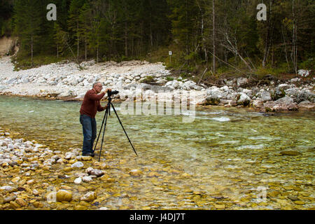 Photographe à un flux dans les Alpes Juliennes en Slovénie Banque D'Images