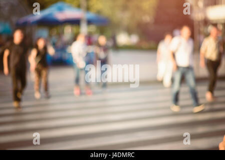 Méconnaissable piétons traversant la rue sur zebra. arrière-plan flou de personnes marchant dans la rue. image filtrée avec filtre vintage. Banque D'Images