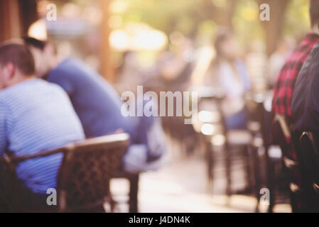 Personnes dans un café avec l'arrière-plan flou flou lumières, vintage filtre pour effet ancien, arrière-plan flou Banque D'Images