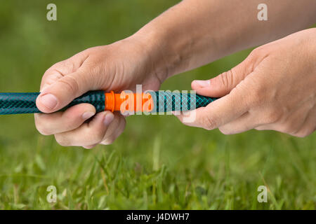 Les mains des flexibles de raccordement pour l'irrigation de jardin Banque D'Images