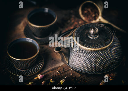 Fer noir théière avec tasse de thé chaud Banque D'Images