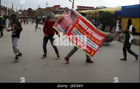 Srinagar, au Cachemire. 12 mai, 2017. .Un manifestant du Cachemire est titulaire d'étendard de pellet victime. Des heurts ont éclaté entre les manifestants et les forces de sécurité au centre-ville de Nowhatta domaine de Srinagar. Des groupes de jeunes se livraient à pierre- slogans et à bombarder les forces de sécurité indiennes peu après les prières de la congrégation vendredi. Selon le rapport, 102 civils non armés ont été tués en 135 jours d'agitation qui a été déclenchée par l'assassinat le 8 juillet de Hizbul Mujahideen Burhan commandant Wani par les forces armées. Credit : Sofi suhail/Alamy Live News Banque D'Images