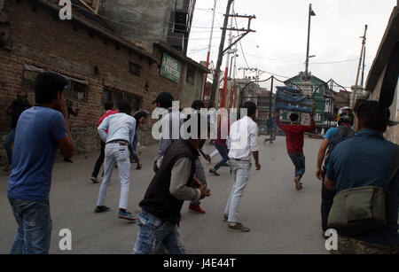 Srinagar, au Cachemire. 12 mai, 2017. Les manifestants jettent du cachemire de briques. Des heurts ont éclaté entre les manifestants et les forces de sécurité au centre-ville de Nowhatta domaine de Srinagar. Des groupes de jeunes se livraient à pierre- slogans et à bombarder les forces de sécurité indiennes peu après les prières de la congrégation vendredi. Selon le rapport, 102 civils non armés ont été tués en 135 jours d'agitation qui a été déclenchée par l'assassinat le 8 juillet de Hizbul Mujahideen Burhan commandant Wani par les forces armées. Credit : Sofi suhail/Alamy Live News Banque D'Images