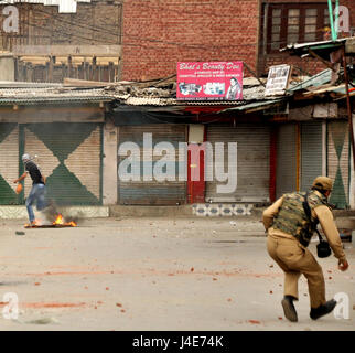 Srinagar, au Cachemire. 12 mai, 2017. La police à la poursuite d'un manifestant Crédit : Arbaz Mughal/Alamy Live News Banque D'Images