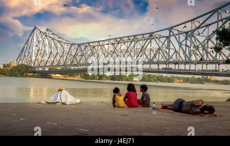 Les enfants de la rue apprécier la vue de l'Howrah Bridge à partir de la banque de la rivière Hooghly mallick à ghat, Kolkata, Inde. Banque D'Images