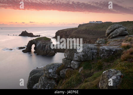 Un coucher de soleil colorés donnant sur les îles de Enys Dodnan et le chevalier armé à Lands End, Cornwall, Angleterre, Royaume-Uni Banque D'Images