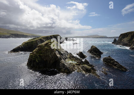 D'énormes nuages d'ouvrir la voie à la lumière du soleil à la lumière les falaises et les îles de St Ninian's Bay, Shetland, Scotland, UK Banque D'Images