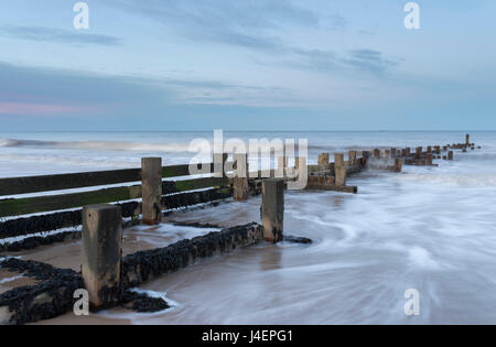 Les vagues frapper un épi à Walcott, Norfolk, Angleterre, Royaume-Uni, Europe Banque D'Images