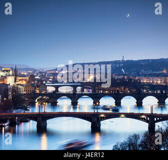 Le crépuscule s'allume les ponts et bâtiments historiques reflétés sur la rivière Vltava, Prague, République Tchèque, Europe Banque D'Images