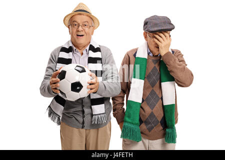 Deux vieux fans de football avec l'un d'entre eux et d'encouragement l'autre tenait la tête dans l'incrédulité isolé sur fond blanc Banque D'Images