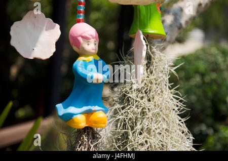 Clay girl doll accroché sur l'arbre pour la décoration de jardin à l'extérieur de la maison Banque D'Images