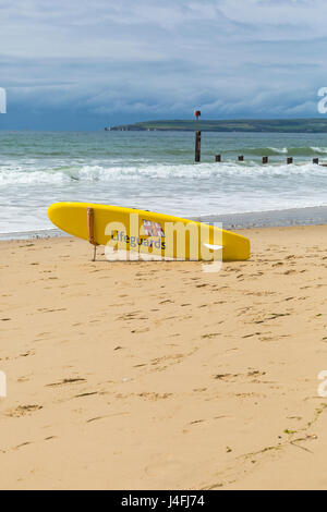 La vie des sauveteurs RNLI surf traîneau au bord de la mer, sur la plage de Bournemouth en mai avec l'Purbecks dans la distance Banque D'Images