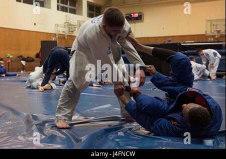 Misawa endurer de jiu-jitsu brésilien au cours d'un espar membres pratique à Misawa Air Base, Japon, le 17 février 2016. Bien que ce style d'arts martiaux contient des mouvements permanent, il est connu pour ses techniques de combat au sol. Les pratiques de Misawa BJJ trois fois par semaine pour mieux développer leurs compétences. (U.S. Air Force photo par un membre de la 1re classe Jordyn Fetter) Banque D'Images