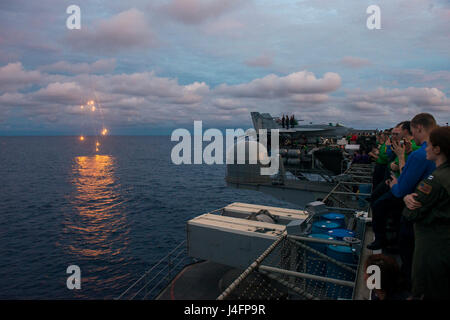 160704-N-SUR707-155 Mer de Chine du Sud (4 juillet 2016) Les marins à bord de la Marine est qu'avant-déployé porte-avions USS Ronald Reagan (CVN 76) regardez comme balles traçantes du navire de calibre 50 de fusils et les fusées d'artifice servent de navire au cours des célébrations du Jour de l'indépendance. Ronald Reagan, fleuron du groupe aéronaval (CSG), 5 est en patrouille dans la 7e Flotte des États-Unis à l'appui de la zone de responsabilité de la sécurité et de la stabilité dans la région du Pacifique-Indo-Asia. (U.S. Photo par marine Spécialiste de la communication de masse 2e classe James Mullen/libérés) Banque D'Images