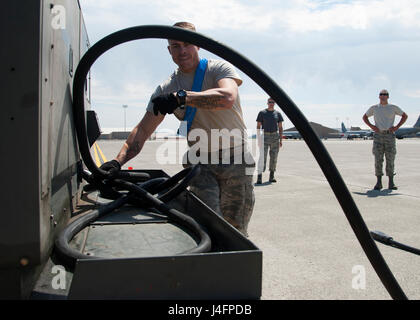 Le personnel. Le Sgt. Robert Goodman, 92e Groupe d'entretien général chef d'équipage de vol des aéronefs, des boucles d'un 100 pi. de long câble d'alimentation de l'avion sur un panier d'utilité au cours de la troisième étape de la Fairchild MXG Relais Olympique sur la concurrence, le 5 août 2016, à Fairchild Air Force Base, dans l'état de la 100 pieds de long câble d'alimentation pèse environ 300 livres. Banque D'Images