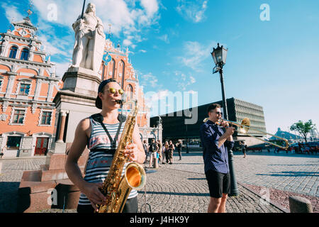 Riga, Lettonie - 1 juillet 2016 : Street Music Trio Groupe de trois jeunes musiciens gars jouant les instruments pour le don sur la place de l'hôtel de ville, célèbre Banque D'Images