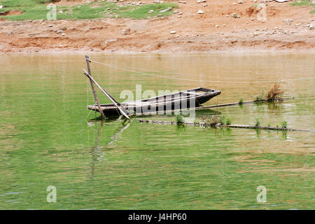 Un sampan traditionnel chinois attaché à un poteau sur le piège de pêche rivière Yangtze. Banque D'Images