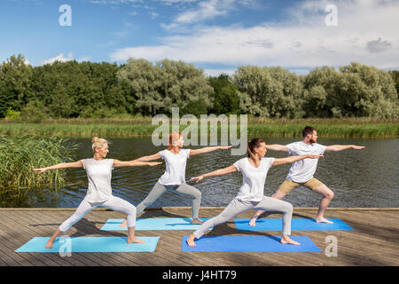 Groupe de personnes faisant des exercices de yoga en plein air Banque D'Images