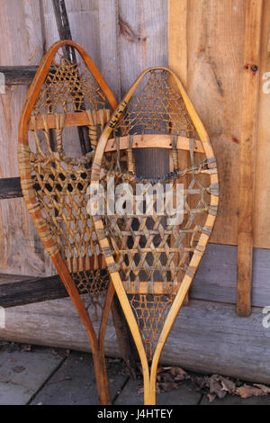 Snowshoes leaning against log cabin en hiver. Banque D'Images