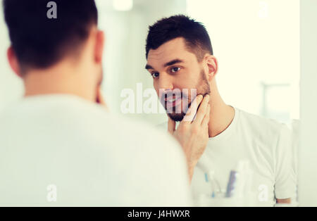 Heureux jeune homme à la recherche de miroir à Accueil Salle de bains Banque D'Images