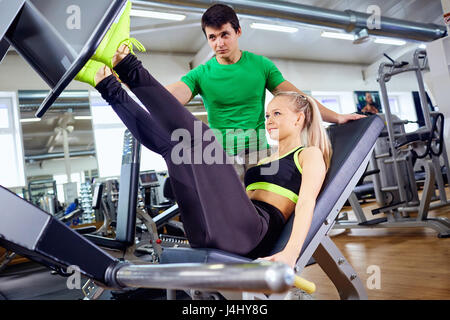 Une fille est en train de faire des exercices sur simulateur avec le pied t personnels Banque D'Images