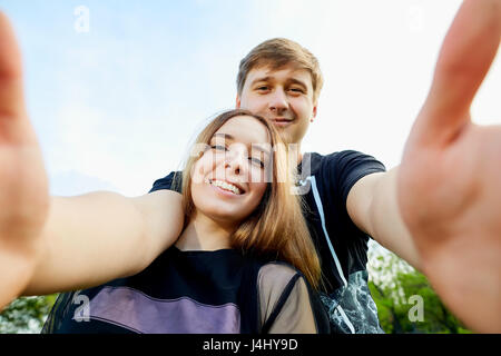 Couple rend le téléphone à l'extérieur sur les selfies Banque D'Images