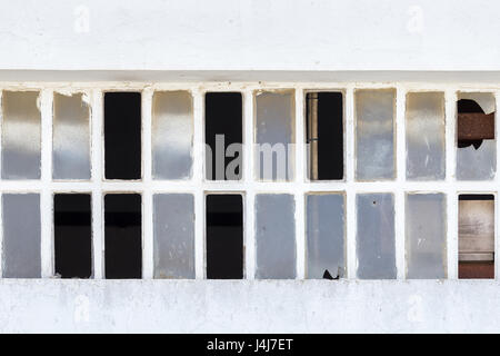 Fenêtre cassée sur un mur blanc, gros plan Banque D'Images
