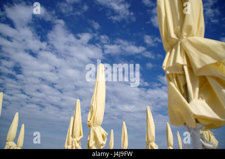 Les parasols de plage jaune fermé en journée ensoleillée Banque D'Images