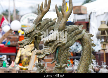 Une paire de statues dragon asiatique lors d'une foire à la brocante en plein air. Banque D'Images