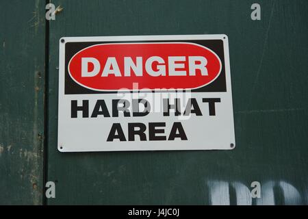 Danger zone casque sign sur construction mur vert en milieu urbain ville Banque D'Images